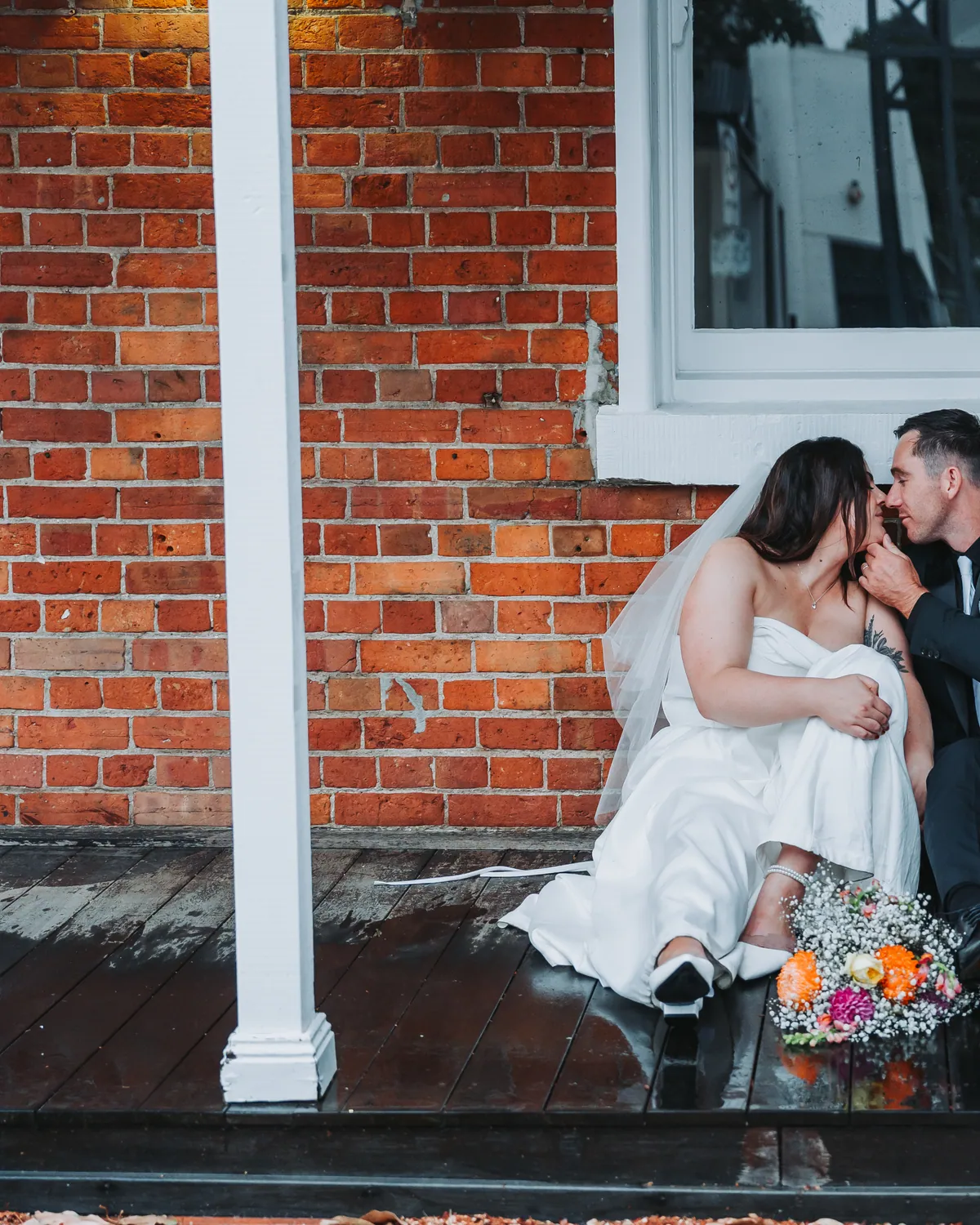 Alex and Steve resting on a brick step after the ceremony