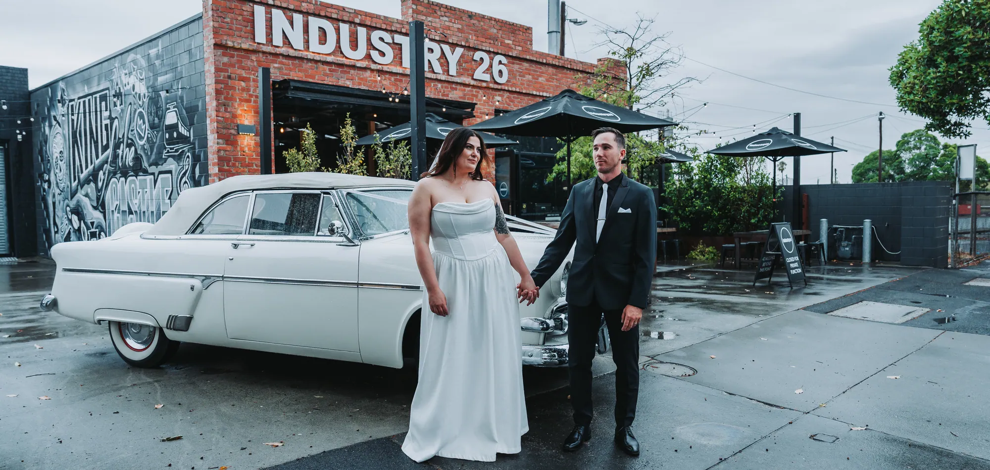 Alex and Steve beside a vintage car outside Industry 26