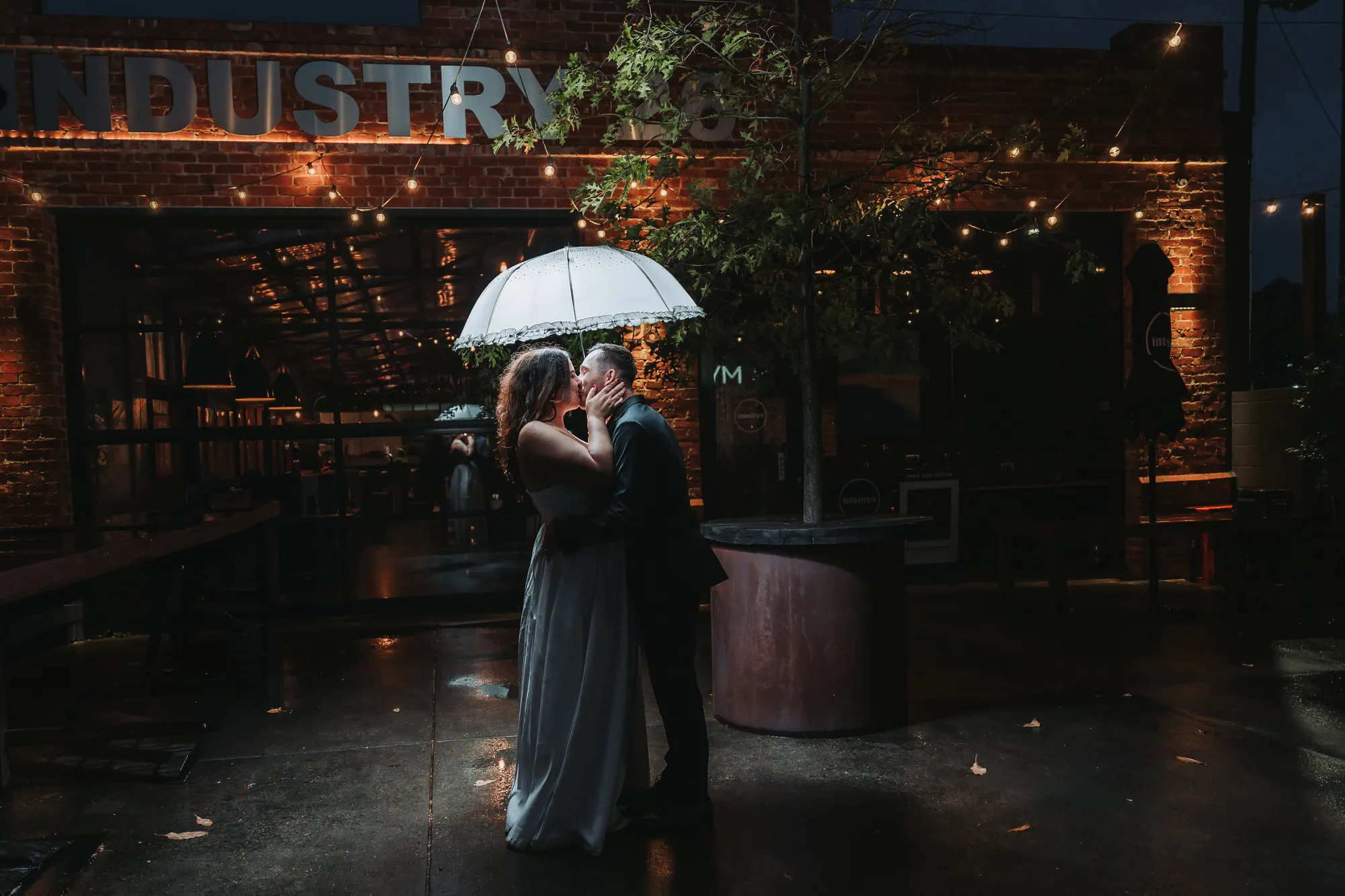 Alex and Steve sheltering under an umbrella outside Industry 26, Geelong